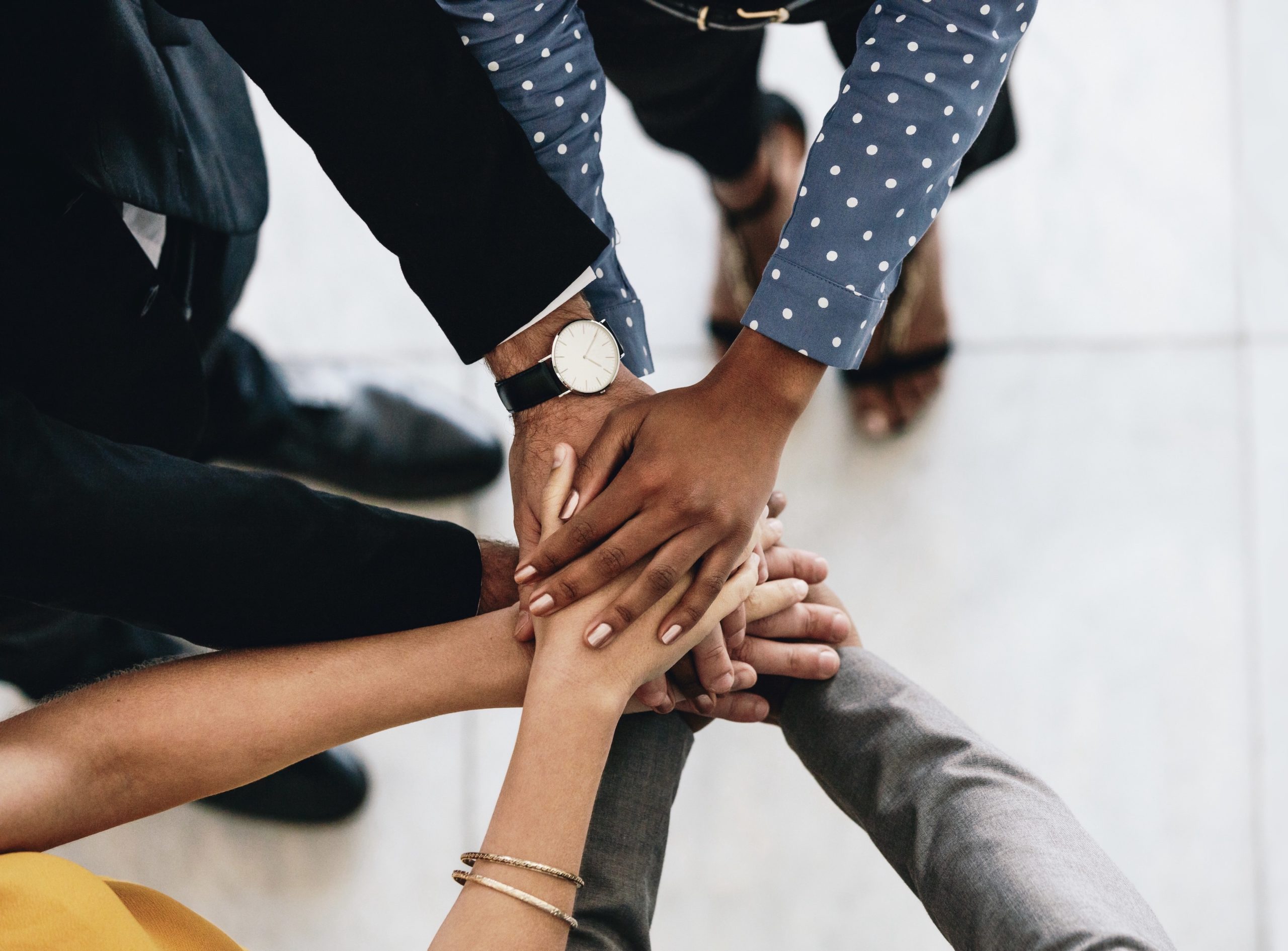 Close up of business people putting their hands together. Business colleagues showing unity.